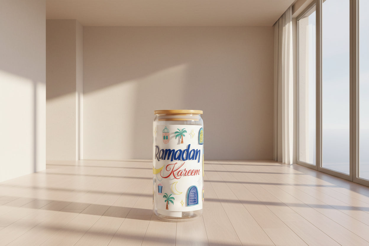 A glass can with 'Ramadan Kareem' and decorative elements like palm trees and a moon.
